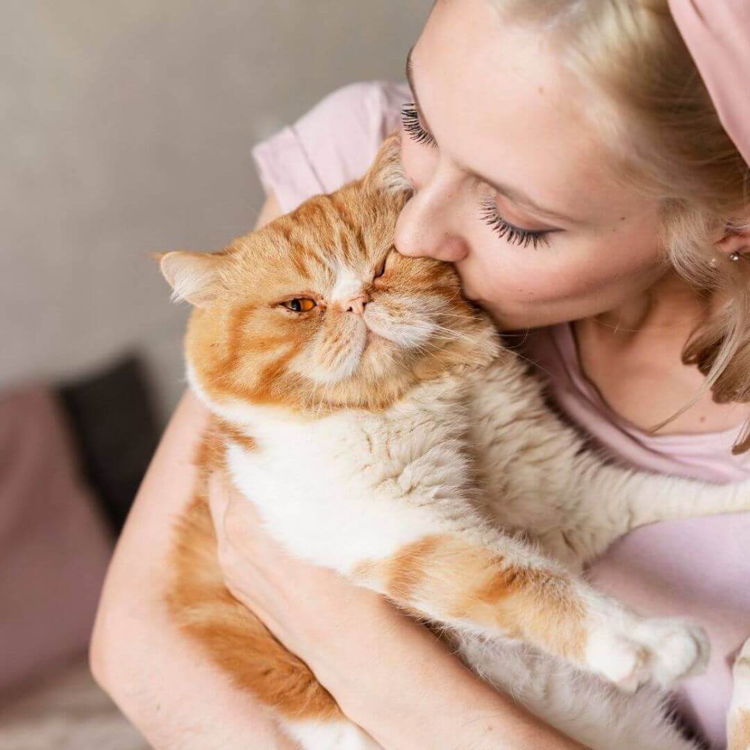 a woman kissing her cat